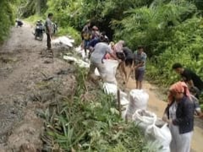 Bhabinkamtibmas, Pangulu dan Warga Bersihkan Timbunan Tanah Longsor di Silau Kahean